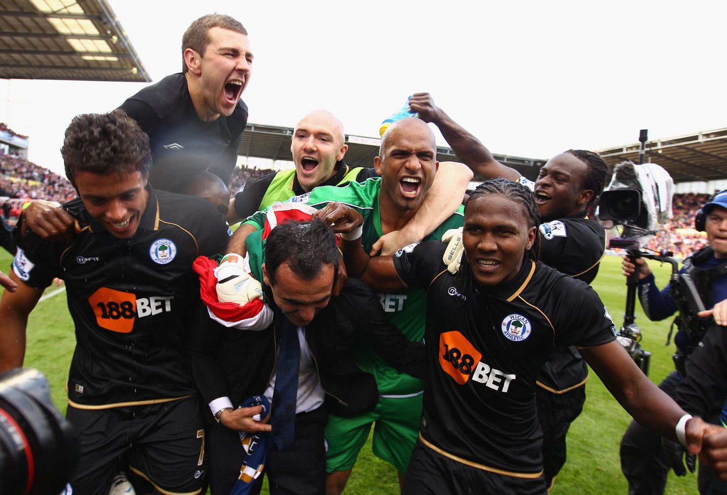 James McArthur (top left) joins the celebrations as Wigan stay up