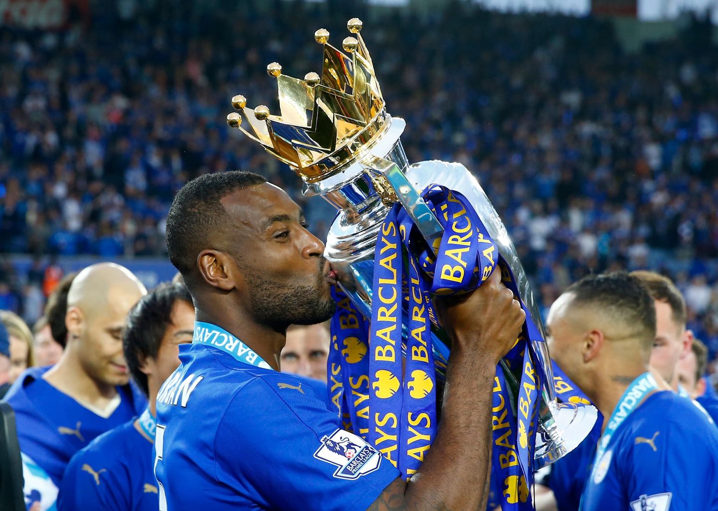 Wes Morgan kisses the Premier League trophy