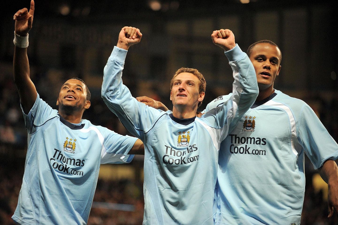 Elano celebrates a goal with Robinho and Vincent Kompany
