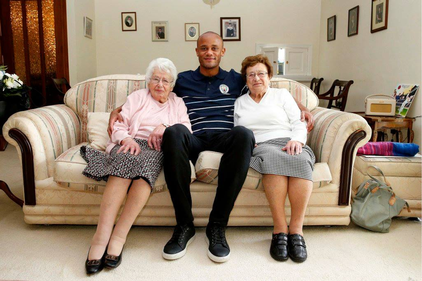 Vincent Kompany with two Manchester City fans