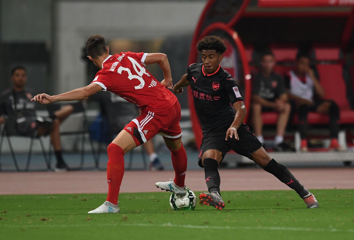 Arsenal's Reiss Nelson takes on a Bayern Munich player