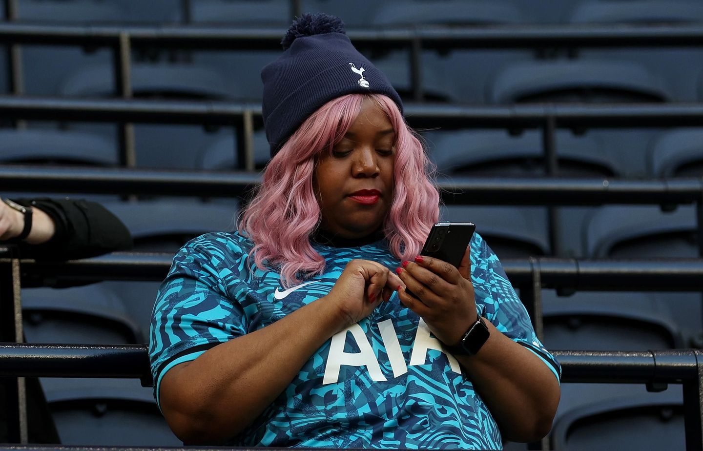 Spurs fan checks her phone