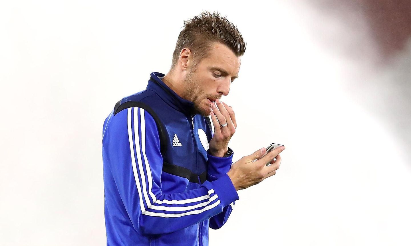 Jamie Vardy looks at a phone