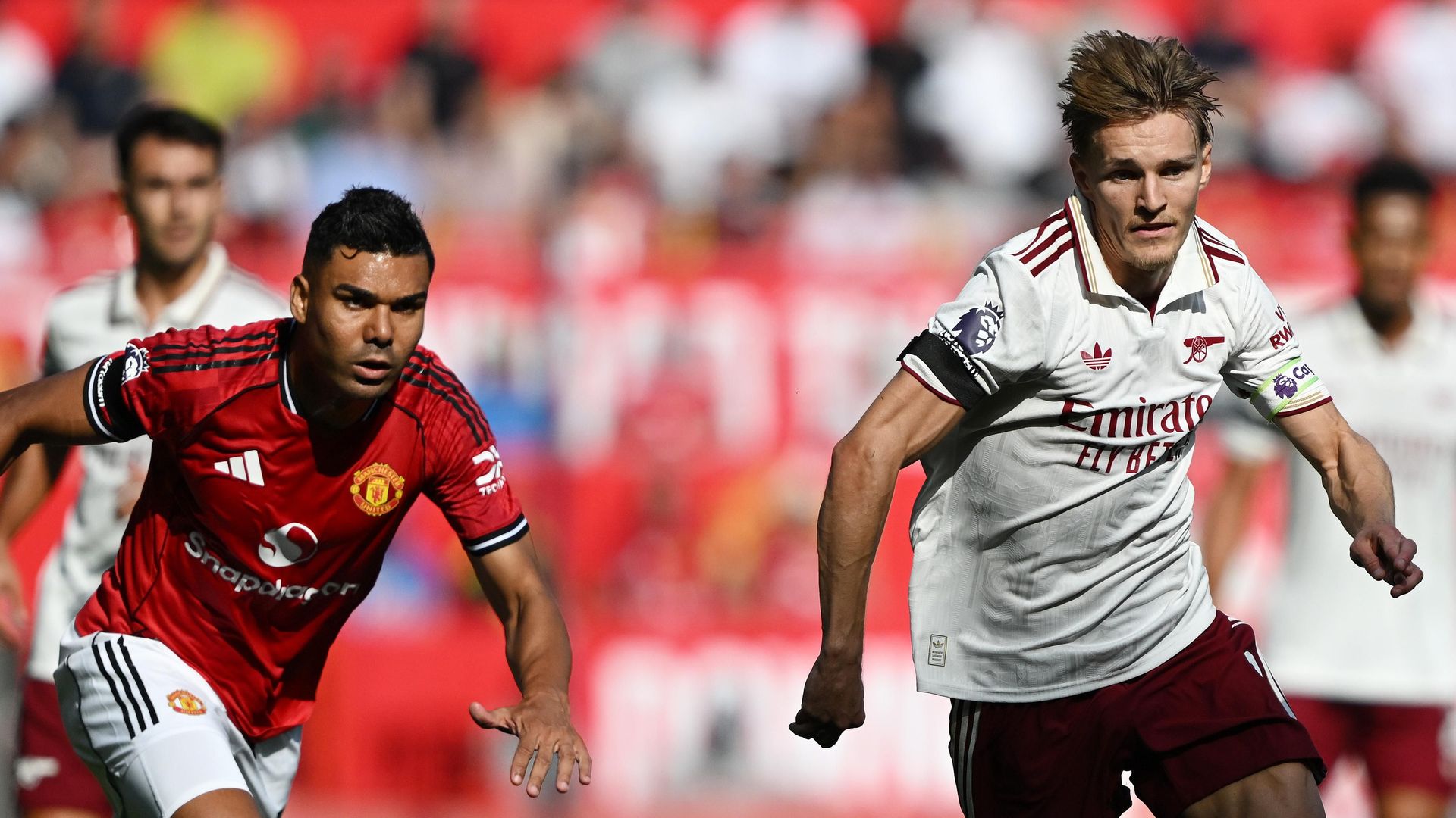 Manchester United v Arsenal - Premier League - Casemio and Odegaard going for a ball