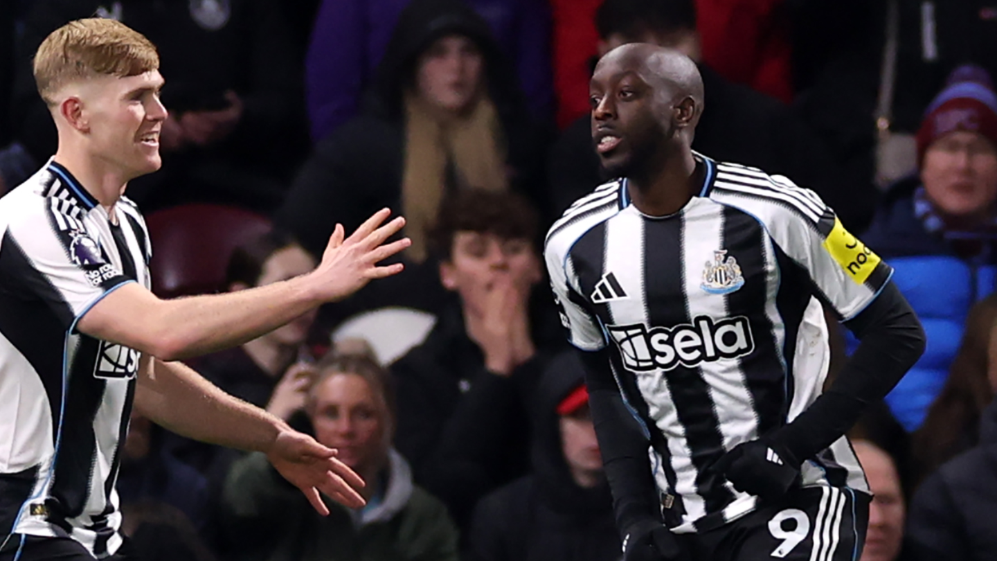 Newcastle defender Lewis Hall congratulates goalscorer Yoane Wissa in front of disappointed Burnley fans in the stands at Turf Moor
