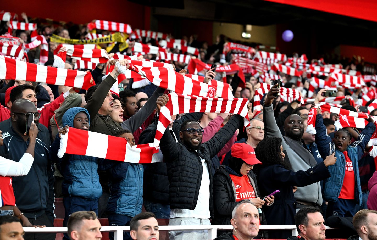 Arsenal fans raise their scarves at Emirates Stadium